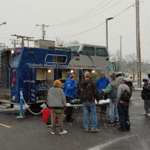 Volunteers with The Sub Zero Mission sorting and loading hats, coats, gloves, boots, and sleeping bags for winter outreach to people experiencing homelessness.