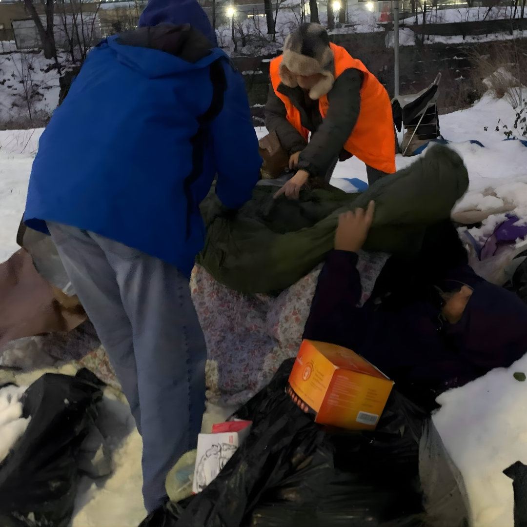 Snow tent volunteers assisting a man
